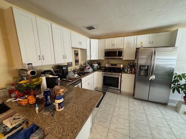 kitchen featuring kitchen peninsula, stainless steel appliances, and white cabinets