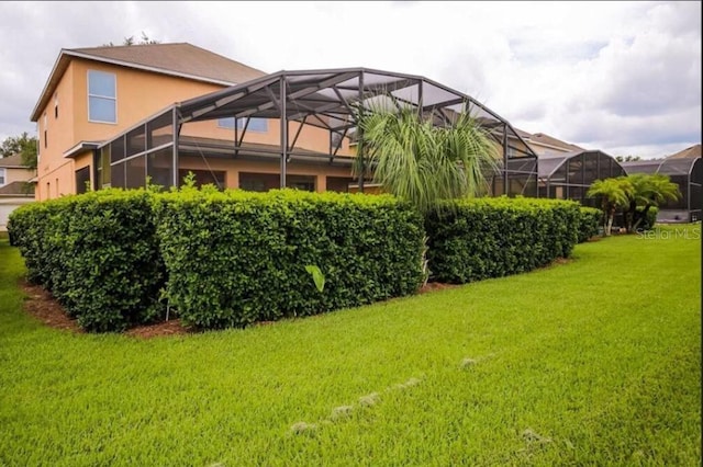 exterior space featuring a lawn and a lanai