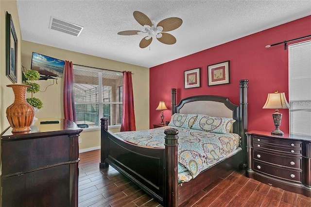 bedroom with ceiling fan, dark hardwood / wood-style flooring, and a textured ceiling