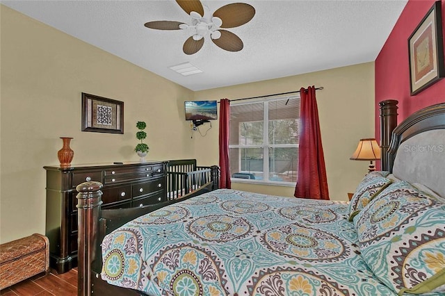 bedroom featuring a textured ceiling, hardwood / wood-style flooring, and ceiling fan