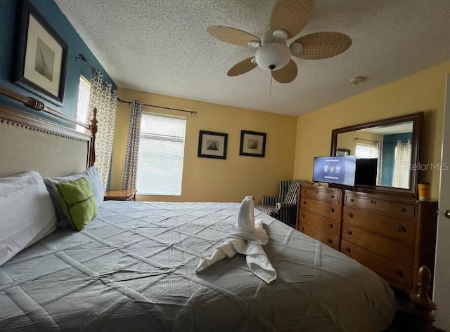 bedroom with ceiling fan and a textured ceiling