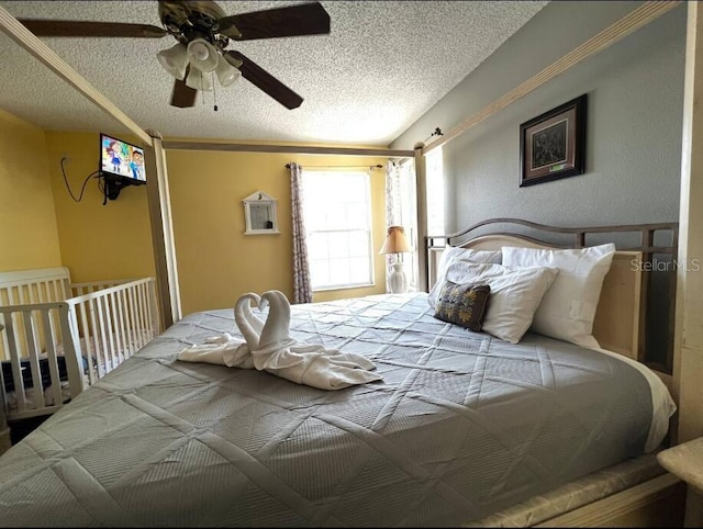 bedroom with ceiling fan and a textured ceiling