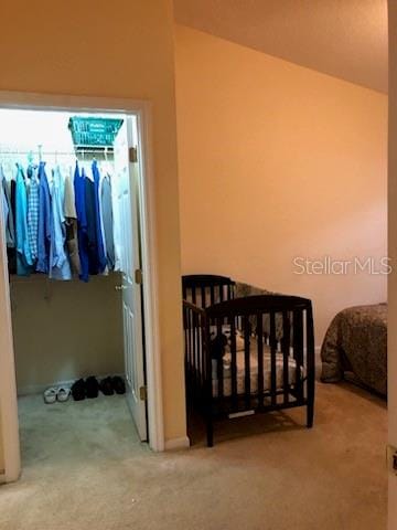 bedroom featuring a nursery area and carpet floors