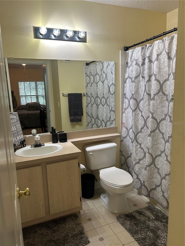 bathroom with tile patterned flooring, toilet, a textured ceiling, vanity, and a shower with curtain