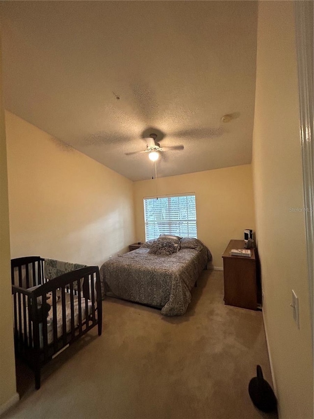 bedroom with carpet floors, a textured ceiling, and ceiling fan