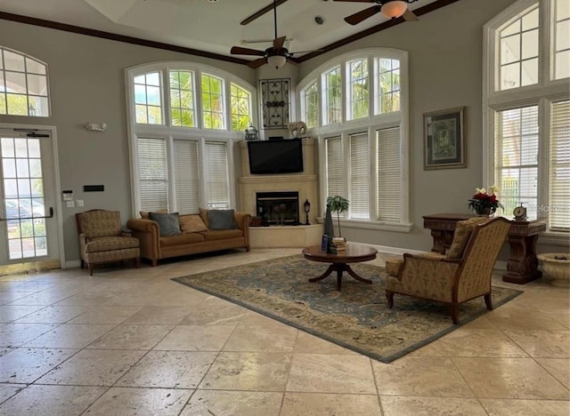 sitting room featuring ceiling fan, crown molding, and a high ceiling