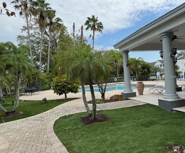 view of home's community featuring a pool, a yard, and a patio area