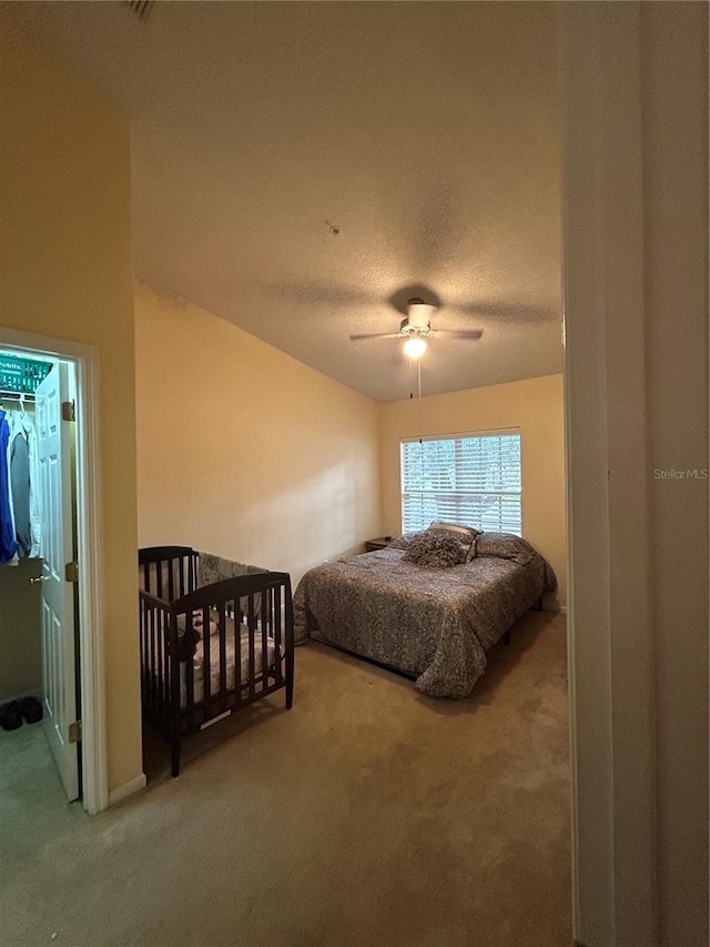 bedroom featuring carpet flooring, a textured ceiling, and ceiling fan