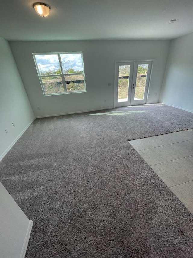 spare room featuring carpet floors and french doors