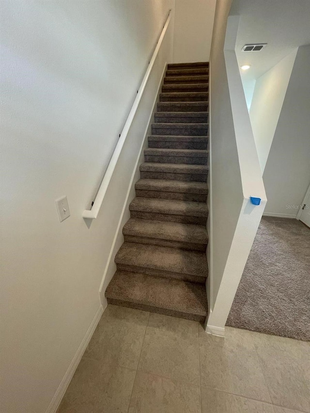 staircase featuring carpet