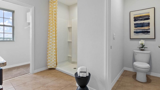 bathroom with a shower, tile patterned flooring, and toilet