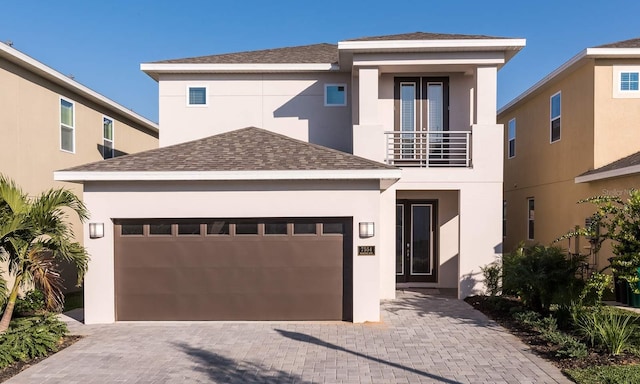 view of front of property featuring a balcony and a garage