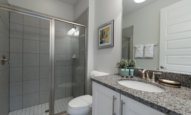 bathroom with a shower with door, vanity, and toilet