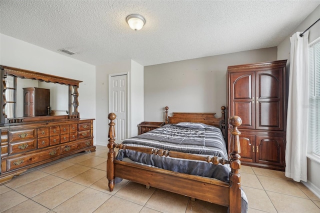 bedroom with light tile patterned flooring and a textured ceiling