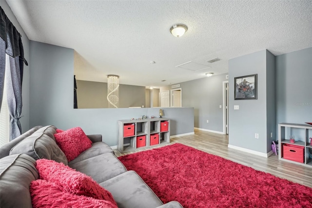 living room with a textured ceiling and light wood-type flooring