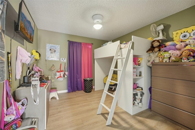 bedroom with light wood-type flooring and a textured ceiling