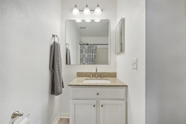 bathroom with wood-type flooring, a shower with curtain, and vanity