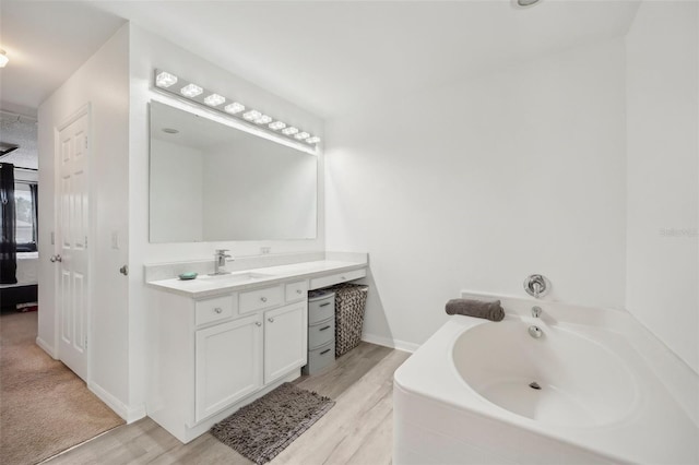 bathroom with vanity, hardwood / wood-style floors, and a washtub