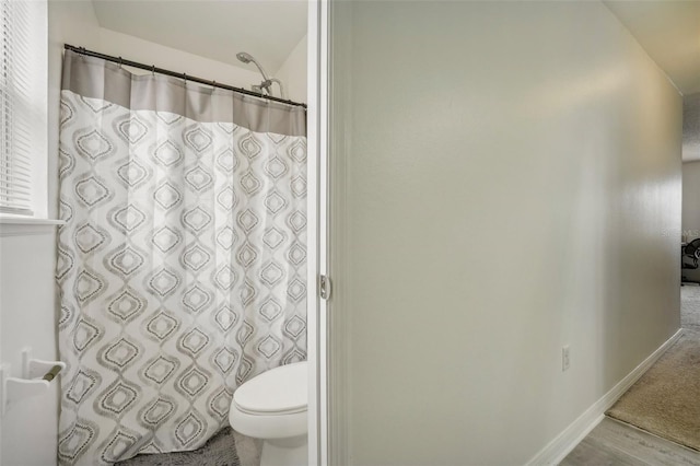 bathroom with walk in shower, hardwood / wood-style floors, and toilet