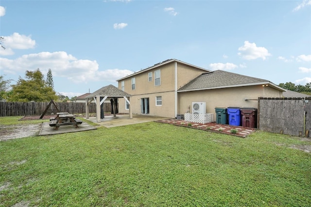 rear view of house featuring a gazebo, a patio area, a fire pit, and a lawn