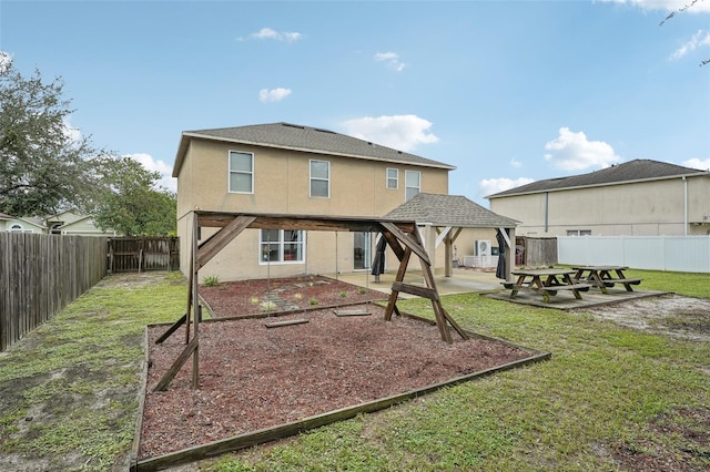 rear view of property with a gazebo, a yard, and a patio area