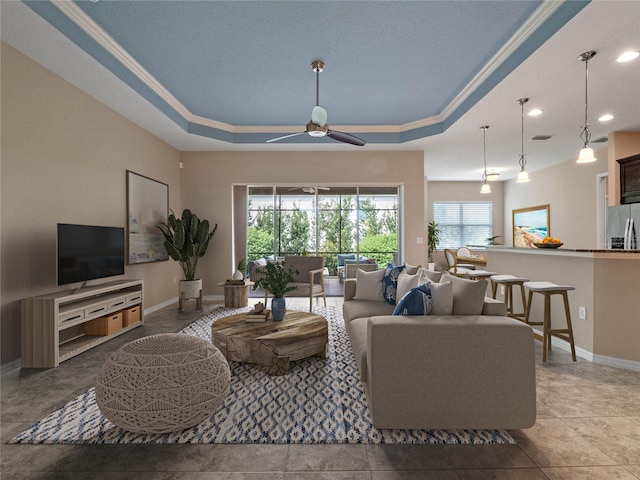 living room featuring crown molding, light tile patterned floors, a tray ceiling, and ceiling fan