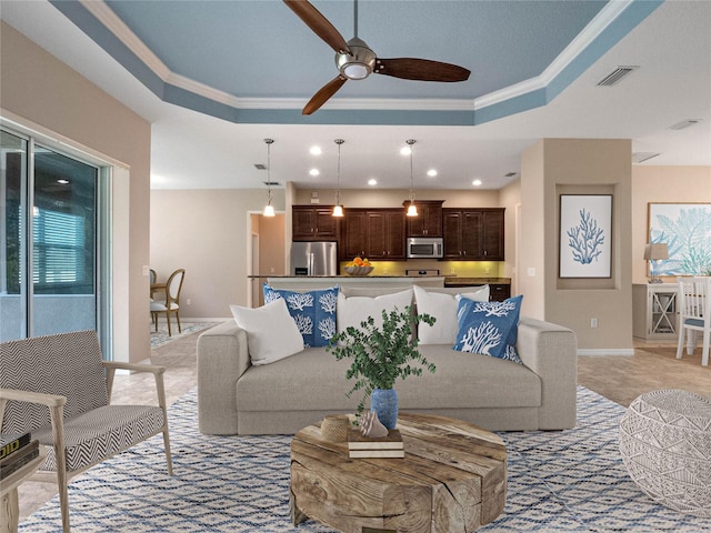 carpeted living room featuring crown molding, a raised ceiling, and ceiling fan