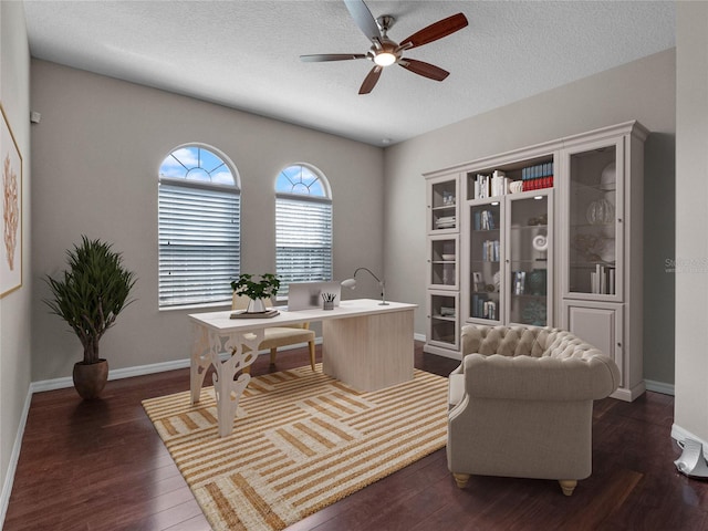 home office with a textured ceiling, ceiling fan, and dark hardwood / wood-style flooring