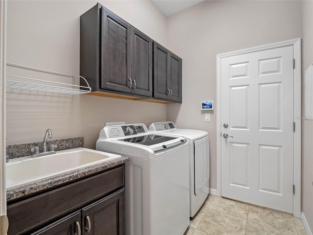 laundry room with sink, light tile patterned flooring, washing machine and dryer, and cabinets