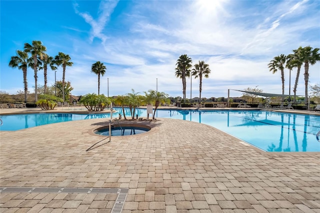 view of swimming pool with a community hot tub and a patio area