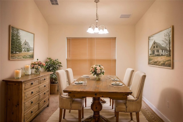 dining area with light carpet and an inviting chandelier