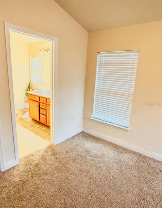 empty room featuring light carpet and vaulted ceiling