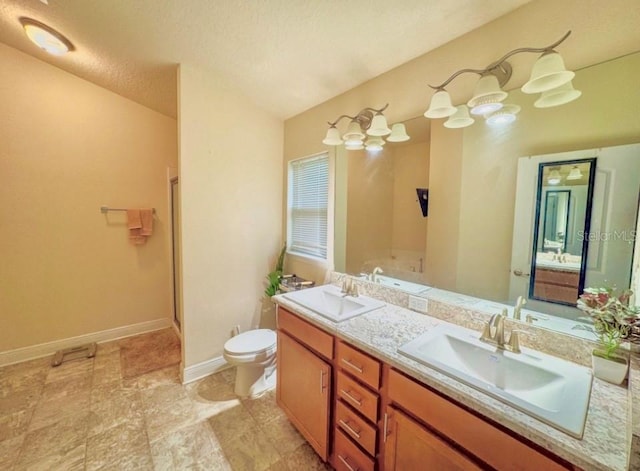 bathroom featuring a textured ceiling, vanity, toilet, and a shower with shower door