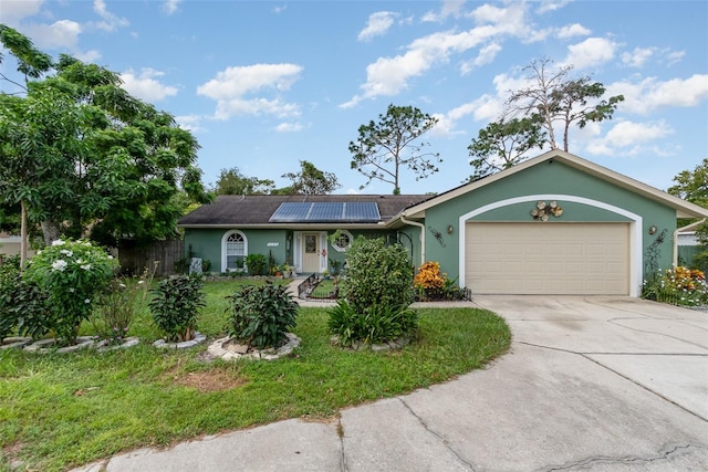 ranch-style home featuring a front yard, solar panels, and a garage