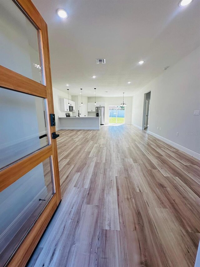 workout area featuring light wood-style floors, recessed lighting, and baseboards
