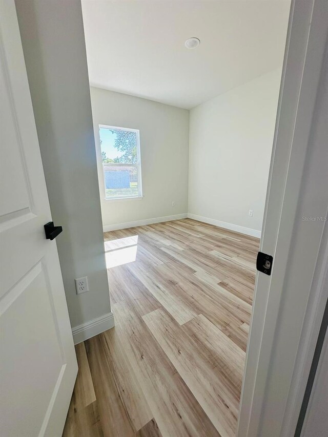 empty room featuring light wood-style floors and baseboards