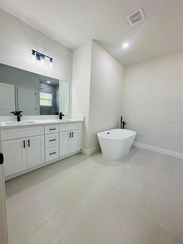 bathroom with double vanity, a shower stall, a soaking tub, baseboards, and recessed lighting