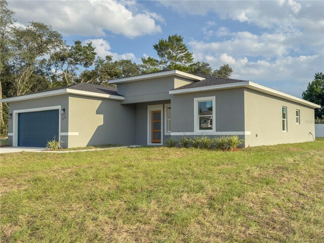 view of front of house featuring stucco siding, an attached garage, and a front lawn