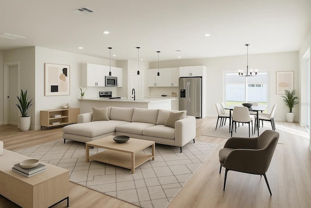 living area with a chandelier, light wood-type flooring, recessed lighting, and baseboards