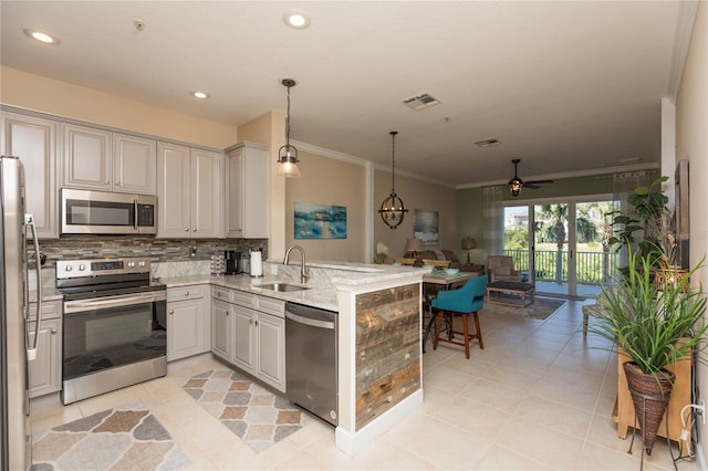 kitchen featuring pendant lighting, sink, kitchen peninsula, stainless steel appliances, and ceiling fan