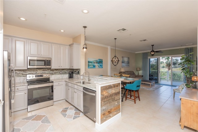 kitchen with visible vents, decorative backsplash, appliances with stainless steel finishes, a sink, and a peninsula