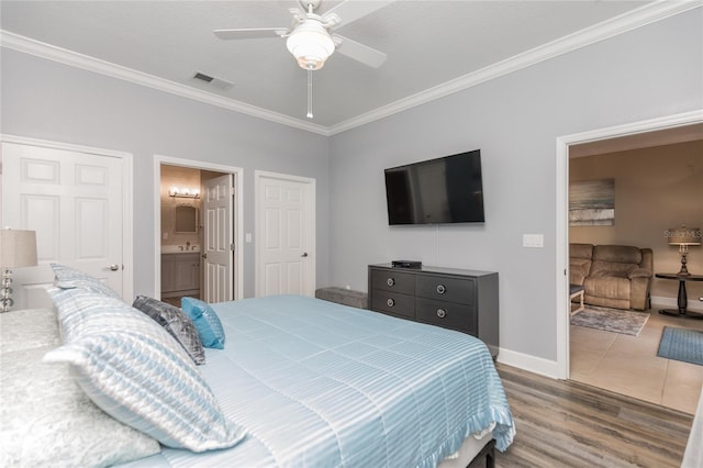 bedroom with ceiling fan, wood finished floors, visible vents, baseboards, and crown molding