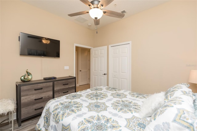 bedroom with a ceiling fan, a closet, visible vents, and wood finished floors