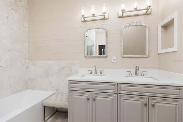 bathroom featuring double vanity, a sink, and a bath