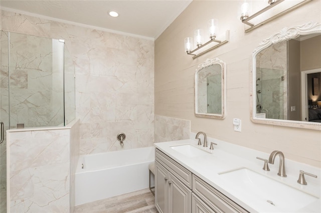 bathroom featuring ornamental molding, a sink, a marble finish shower, and a bath