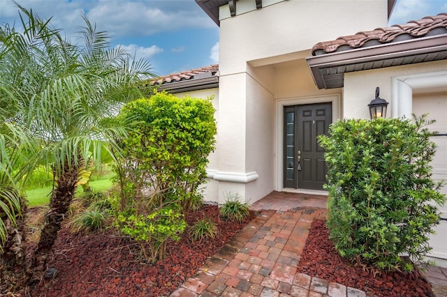 3951 Carrick Bend Dr, Kissimmee, FL 34746 - view of exterior entry featuring a tile roof and stucco siding
