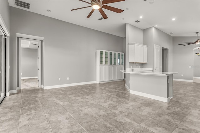 3951 Carrick Bend Dr, Kissimmee, FL 34746 - kitchen featuring light countertops, visible vents, a ceiling fan, open floor plan, and a towering ceiling
