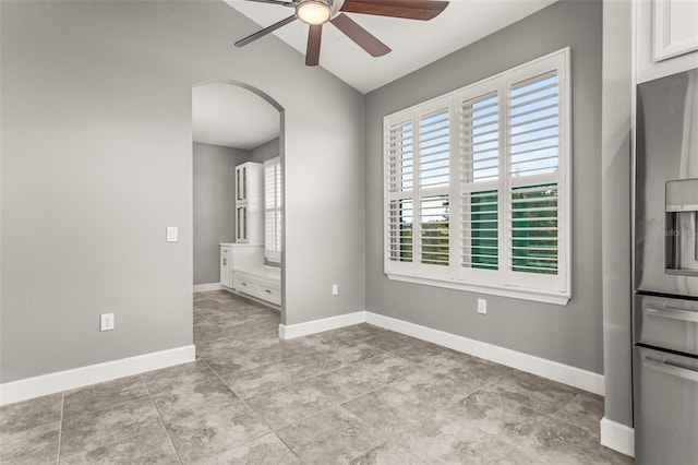 3951 Carrick Bend Dr, Kissimmee, FL 34746 - empty room featuring arched walkways, ceiling fan, lofted ceiling, and baseboards