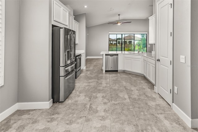 3951 Carrick Bend Dr, Kissimmee, FL 34746 - kitchen featuring a ceiling fan, baseboards, white cabinets, appliances with stainless steel finishes, and lofted ceiling