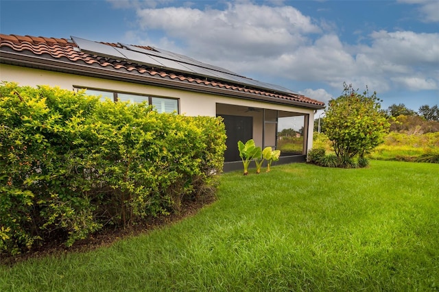 3951 Carrick Bend Dr, Kissimmee, FL 34746 - view of side of home featuring solar panels, a sunroom, a yard, and ceiling fan